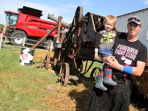 Carl Thompson stands with his three-year-old son Lucas beside a 110-year-old threshing machine the Moore Agricultural Society member helped fix up in time for the Brigden Fair. This year's theme was ‘celebration of rural life.’  Tyler Kula/Sarnia Observer/Postmedia Network