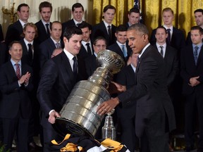 President Barack Obama and Pittsburgh Penguins captain Sidney Crosby set down the Stanley Cup following a ceremony in the East Room of the White House in Washington on Oct. 6, 2016, where the president honored the 2016 Stanley Cup champion Pittsburgh Penguins. (THE CANADIAN PRESS/AP/Susan Walsh)