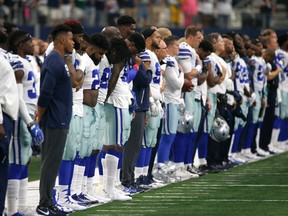 The Dallas Cowboys and staff stand on the sideline during the playing of the national anthem before the first half of an NFL football game against the Green Bay Packers on Sunday, Oct. 8, 2017. (AP Photo/Ron Jenkins)