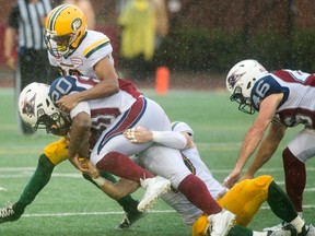 Montreal Alouettes' Tyrell Sutton (20) is tackled by Edmonton Eskimos' defenders during first half CFL football action in Montreal, Monday, October 9, 2017.