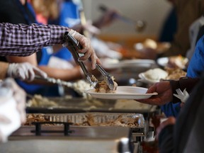 Volunteers serve dinner during the Annual Community Thanksgiving Luncheon organized by the Millbourne Laundromat and the Rotary Club of Edmonton Southeast at Leefield Community League hall in Edmonton, Alberta on Monday, October 9, 2017. Ian Kucerak / Postmedia