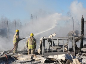 Volunteer firefighters extinguish hot spots at a barn fire in Dowling in 2012. (John Lappa/Sudbury Star file photo)