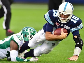 Toronto Argonauts quarterback Ricky Ray dives with the ball as he's tackled by Saskatchewan Roughriders linebacker Derrick Moncrief during CFL action in Toronto on Oct. 7, 2017. (THE CANADIAN PRESS/Frank Gunn)