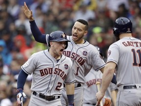Astros third baseman Alex Bregman (2) celebrates his home run with Carlos Correa (rear) and Evan Gattis (right) during the eighth inning of Game 4 of the American League Division Series against the Red Sox in Boston on Monday, Oct. 9, 2017. (Charles Krupa/AP Photo)