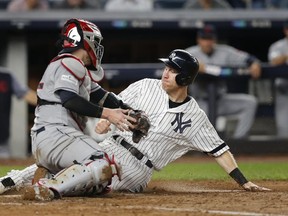 Yankees' Todd Frazier (right) slides safely into home plate ahead of the tag from Indians catcher Roberto Perez on a sacrifice fly by Brett Gardner during the fifth inning in Game 4 of the American League Division Series in New York on Monday, Oct. 9, 2017. (Kathy Willens/AP Photo)
