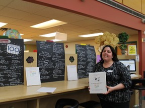 Ardis Chedore stands in front of the display depicting the Cochrane Public Library's history in the community. Patrons are invited to share their thoughts on what the library has meant to them.