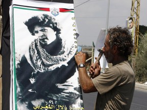 A Lebanese man hangs a poster of Palestinian Fatah member Dalal al-Mughrabi in Naqura in southern Lebanon on July 15, 2008. (Ramzi Haidar/Getty Images)