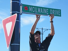 A sign honouring a family of veterans gets installed on Oct. 5 (Peter Shokeir | Whitecourt Star).