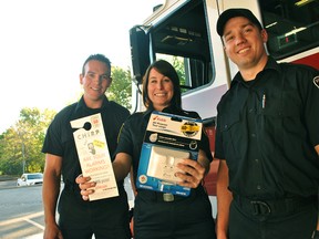 Chatham-Kent Fire and Emergency Services public educator Whitney Burk (centre) holds up a door hanger for the department's CHIRP program and a carbon monoxide detector next to firefighters Phil Resendes (left) and Ben Fisher at Chatham-Kent Fire Station 1. Oct. 8 to 14 is Fire Prevention Week.