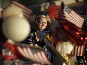 Alexandra Gurr cries as she lays flowers at a makeshift memorial for victims of a mass shooting Monday, Oct. 9, 2017, in Las Vegas. (AP Photo/John Locher)