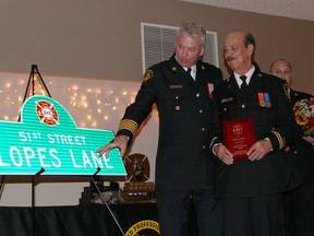Whitecourt Fire Chief Brian Wynn (left) and Captain Larry Lopes look at the street sign named in Lopes's honour on Oct. 24, 2015 (File Photo).