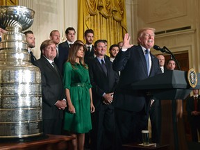 President Donald Trump talks about the 2017 NHL Stanley Cup Champion Pittsburgh Penguins on Oct. 10, 2017. First lady Melania Trump, in green, and Penguins owner Ronald Burkle, center, listen. (AP Photo/Susan Walsh)