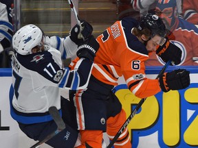 Edmonton Oilers Adam Larsson (6) hits  Winnipeg Jets Adam Lowry during second period NHL action at Rogers Place in Edmonton, October 9, 2017.