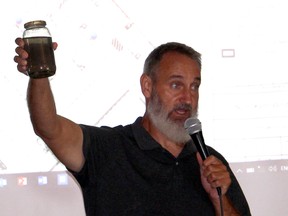 Water Wells First spokesperson Kevin Jakubec holds up a sediment-filled jar of water taken from a local water well after pile driving took place nearby for an industrial wind turbine during a public meeting held on Sunday September 24, 2017. Wallaceburg Coun. Jeff Wesley says the Municipality of Chatham-Kent is willing to pay to have sediments found in impacted water wells tested, but so far, no one is taking the offer. (Ellwood Shreve/Chatham Daily News)