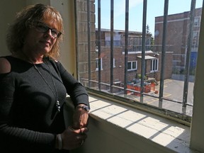 Sonya Spencer, of the John Howard Society, looks from a room in a planned haflway house that overlooks St. Thomas Aquinas Elementary School. (DAVE ABEL, Toronto Sun).