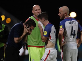 United States' Christian Pulisic (center) and his teammate Michael Bradley (right) walk on the pitch after losing to Trinidad and Tobago during a 2018 World Cup qualifying soccer match in Couva, Trinidad, on Tuesday, Oct. 10, 2017. (Rebecca Blackwell/AP Photo)