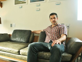 John Fry, owner of JM Fry Furniture Design, is shown on one of the customized pieces of furniture inside his Chatham store on Oct. 10. The company is a finalist in a contest to win a portion of $30,000.