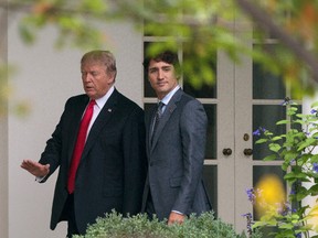 President Donald Trump and Canadian Prime Minister Justin Trudeau walk along the Colonnade to the Oval Office of the White House in Washington, Wednesday, Oct. 11, 2017. (AP Photo/Carolyn Kaster)