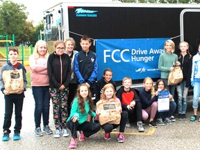 Members of Mrs. Therrien's Grade 7 French immersion class at Errol Road Public School stand in front of Farm Credit Canada's tractor and trailer on Wednesday after having donated 1,400 cans of food to the Inn of the Good Shepherd in Sarnia (Carl Hnatyshyn/Postmedia Network)