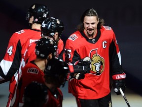 Injured Ottawa Senators defenceman Erik Karlsson bumps gloves with teammates during player introductions prior to NHL action against the Washington Capitals in Ottawa on Oct. 5, 2017. (THE CANADIAN PRESS/Adrian Wyld)