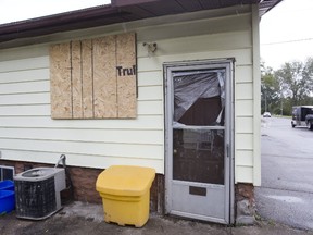 Windows are boarded up and broken at  the London house where Raymond Beaver was stabbed to death during a home invasion last week. (DEREK RUTTAN, The London Free Press)