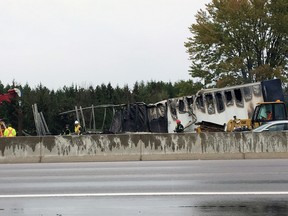 Tow truck operations remove the burnt carcass of a transport truck on Highway 401 in Kingston, Ont. on Wednesday October 11, 2017. Steph Crosier/Kingston Whig-Standard/Postmedia Network