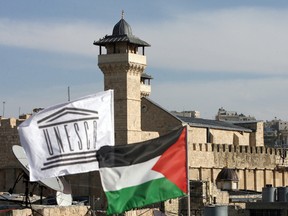 The UNESCO flag flies next to the national Palestinian flag in front of Hebron's Ibrahimi Mosque or the Tomb of the Patriarchs in the southern West Bank city's old quarter on December 13, 2011. (Hazem Bader/Getty Images)