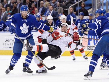 Toronto Maple Leafs defenceman Ron Hainsey (2) knocks down New Jersey Devils left wing Marcus Johansson (90) during third period NHL hockey action in Toronto on Wednesday, October 11, 2017. (Nathan Denette/THE CANADIAN PRESS)