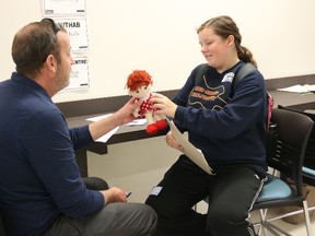 BRUCE BELL/THE INTELLIGENCER
Jim Reilly, a teacher with the Algonquin & Lakeshore Catholic District School Board, acts as a volunteer during the Poverty Challenge at Loyalist College on Friday. Reilly is being asked by ‘Michelle,’ a young mother, to look after her baby while she tries to make living arrangements. It was just one of the exercises close to 100 local high school students went through to learn about poverty.