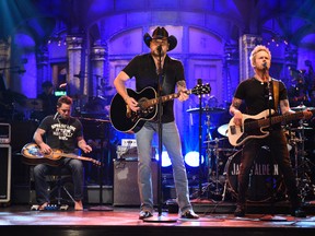 In this photo provided by NBC, Jason Aldean performs "I Won't Back Down" on "Saturday Night Live," in New York on Oct. 7, 2017. Aldean will return to touring following the Las Vegas mass shooting on Oct. 1. (Will Heath/NBC via AP)