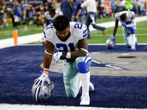 In this Sept. 10, 2017, file photo, Dallas Cowboys running back Ezekiel Elliott (21) kneels in prayer in the end zone before an NFL football game against the New York Giants in Arlington, Texas. (AP Photo/Roger Steinman, File)