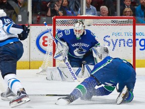 Jets’ Shawn Matthias (left) fires a shot on net against the Canucks at the Rogers Arena in Vancouver last night. (Getty Images)