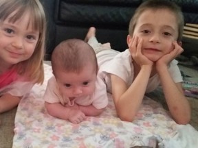 Jack Skrt, right, poses with his younger sisters Emily, 3, left, and Leah, three-months-old, in July 2017. An Ontario family has launched a human rights complaint against a school board in an effort to get a popular form of therapy for autistic children provided to their son in class. (HANDOUT/THE CANADIAN PRESS)