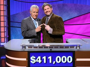 This image released by Jeopardy Productions, Inc. shows "Jeopardy!" host Alex Trebek, left, and contestant Austin Rogers, whose 12-game winning streak came to an end on Thursday's broadcast. Rogers finished his run in fifth place on the all-time regular-season (non-tournament), winning $411,000. (Carol Kaelson/Jeopardy Productions, Inc. via AP)