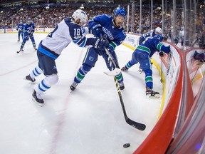 Winnipeg Jets' Bryan Little (18) checks Vancouver Canucks' Michael Del Zotto (4) during the third period of an NHL hockey game in Vancouver, B.C., on Thursday October 12, 2017. THE CANADIAN PRESS/Darryl Dyck