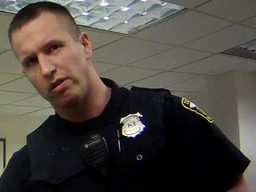 In this April 13, 2017, file image taken from video provided by the Euclid Police Department, Euclid police officer Michael Amiott stands in a public library in Euclid, Ohio. (Euclid Police Department via AP, File)