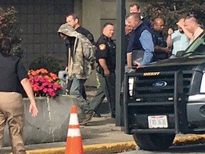 This photo taken from video shows suspect Arron Lawson, centre, escorted into Lawrence County Courthouse Friday Oct. 13, 2017 in Ironton, Ohio. (WCHS-TV via AP)