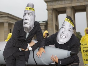 International campaign to abolish Nuclear Weapons (ICAN) activists wearing masks to look like US President Donald Trump and North Korean Kim Jong-Un pose next to a Styrofoam effigy of a nuclear bomb while protesting in front of the Brandenburg Gate near the American Embassy on September 13, 2017 in Berlin, Germany. (Getty Images)