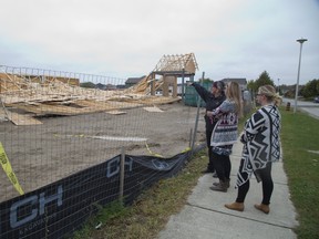 Fran Dow points to where her office was supposed to be in the new Middlesex Mutual Insurance Co. building in Ilderton. Dow and fellow employees Jacqueline Bowyer, middle, and Laura Wigelsworth will have to wait a while to move in after the partly completed building collapsed Saturday. (DEREK RUTTAN, The London Free Press)