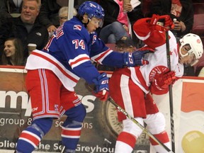 Kitchener Rangers Connor Bunnaman and Soo Greyhounds Keeghan Howdeshell tangle along the boards during first-period action on Nov. 24 at Essar Centre.