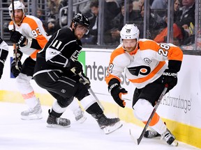 Kings' Anze Kopitar defends against Flyers' Claude Giroux (right) and Jakub Voracek in their opening game of the season. (Harry How, Getty Images)