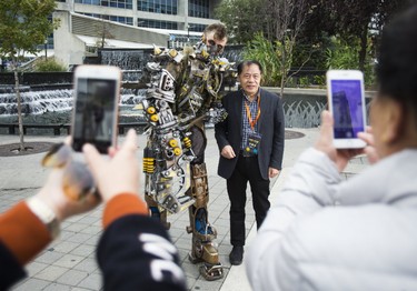 Visitors from China pose for pictures with Toronto-based prop maker/cosplayer Mike Cameron along Bremner Blvd in downtown Toronto, Ont. on Thursday October 12, 2017. Cameron just returned from New York Comic Con. He won Best in Category: Armour, as well as 2nd place overall. Additionally, he took best in show at Toronto's Fan Expo last month. (Ernest Doroszuk/Toronto Sun)