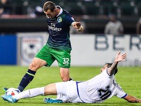 FC Edmonton midfielder Nicolas Di Biase, right, slide tackles New York Cosmos midfielder Bljedi Bardic in North American Soccer League play at MCU Park in New York on Saturday, Oct.14, 2017.