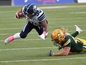 Edmonton Eskimos James Tuck (49) trips up Toronto Argonauts running back Martese Jackson (30) during CFL action at Commonwealth Satdium in Edmonton, October 14, 2017.