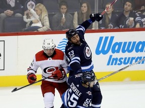 Winnipeg Jets' Dustin Byfuglien (33) tries to hit Carolina Hurricanes' Justin Williams (14) and takes out teammate Mark Scheifele (55) as well during third period NHL hockey action in Winnipeg, Saturday, October 14, 2017. THE CANADIAN PRESS/Trevor Hagan