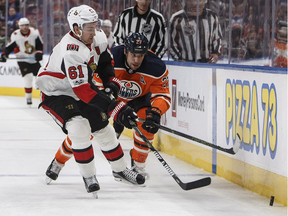 Mark Stone of the Senators pokes the puck away from the Oilers' Milan Lucic along the boards during the second period of Saturday's game in Edmonton. (Jason Franson, THE CANADIAN PRESS)