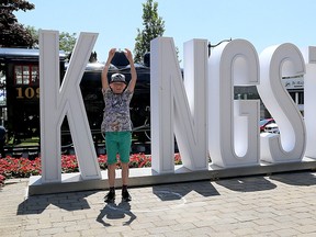 Tourist Jack Foots of Pickering, England, poses with the 'I in Kingston' sign at Confederation Park on June 28. City staff are recommending that the sign stay for another year. (Ian MacAlpine/Whig-Standard file photo)