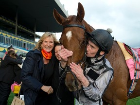 Jockey Oisin Murphy gives Blond Me a kiss alongside the horse's owner, Barbara Keller, after winning the E.P. Taylor Stakes yesterday at Woodbine. (Michael Burns photo)