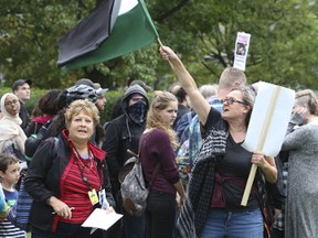 A woman holding a Palestinian flag engages with the Toronto Sun's Sue-Ann Levy, left, at the Unity Rally to End White Supremacy at Queen's Park on Sunday, Oct. 15, 2017. (Stan Behal/Toronto Sun)