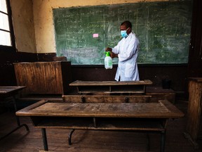 In this photo taken Tuesday Oct. 10, 2017, a member of staff at a school in Antananarivo sprays against plague in a classroom at a school in the capital Antananarivo, Madagascar, as schools remain shut due the outbreak. A plague outbreak has brought panic to the city dwellers with schools closed and public gatherings banned as the death toll still mounts in the Indian Ocean island nation. (AP Photo/Alexander Joe)